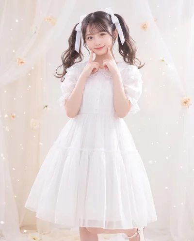 Rino in a white frilled dress with ribboned twin tails, fingers to her cheeks, among gauzy curtains and pale roses