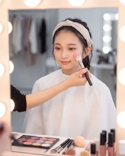 Rino having her makeup done in a mirrored dressing room